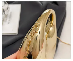Detail shot of the golden mirror acrylic mini bag with integrated handle and chain link