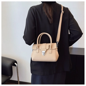 Détail du sac Boston beige en cuir grainé avec fermoir argenté porté par un mannequin