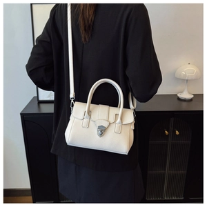 Détail du sac Boston crème en cuir grainé avec fermoir bouclier en métal argenté