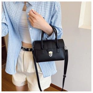 Détail du sac Boston en cuir grainé noir avec finitions argentées sur tenue décontractée