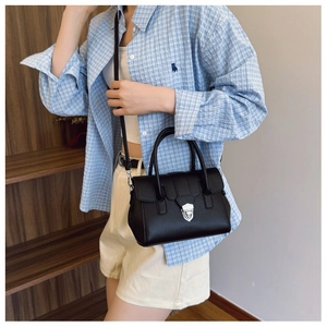 Détail d'un sac Boston en cuir grainé noir avec boucle argentée sur un modèle