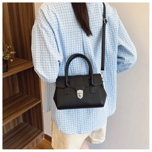 Détail du sac Boston noir grainé avec fermoir argenté et bandoulière amovible