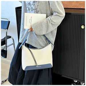 Detail of beige woven texture and blue leather underarm bag with Fashion & Bag text