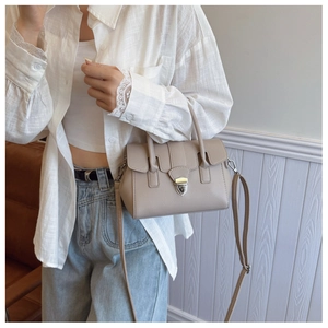 Gros plan d'un sac à main beige en similicuir grainé avec boucle en métal argenté