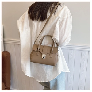 Sac Boston moderne kaki montrant le cuir grainé et la bandoulière réglable pratique