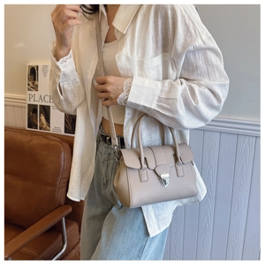 Détail du sac Boston beige en cuir grainé avec fermoir rotatif argenté et bandoulière
