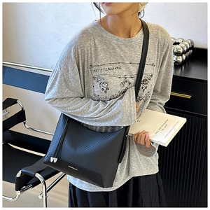 Detail of black woven shoulder bag with FASHION & BAG print and smooth leather trim