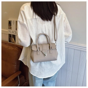 Détail du sac Boston en cuir grainé beige avec boucle argentée et bandoulière amovible