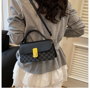 Détail du sac bandoulière avec toile à motif M et fermoir pivotant en métal doré