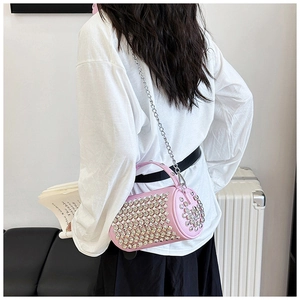 Detail of pink cylindrical rhinestone handbag with silver chain and leather handle