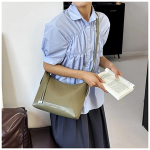 Olive green woven shoulder bag styled with adjustable strap and retro leather stitching