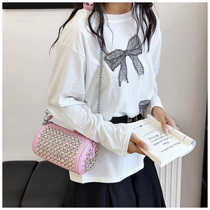 Detail showing pink cylindrical crossbody bag with sparkling rhinestones and silver chain strap