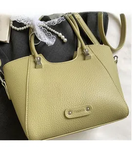 Détail du sac seau vert olive montrant le cuir grainé et l'étiquette mode élégante