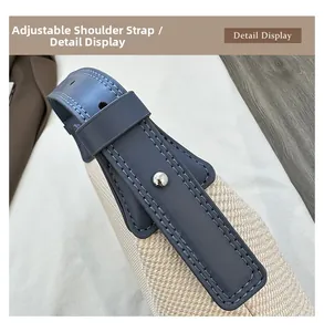 Detail of adjustable blue leather and woven strap with silver metal buckle on shoulder bag