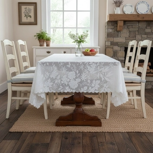 Vintage white lace tablecloth with floral patterns on a rectangular wooden table