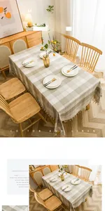 Detail of plaid cotton linen tablecloth with beige tassels and natural texture