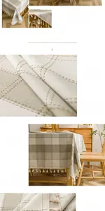 Detail of grey and beige plaid tablecloth featuring rustic linen texture and tassel fringe