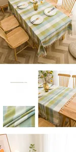 Detailed macro view of green plaid tablecloth with white tassel trim on wooden table