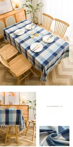 Detailed view of blue checkered waterproof tablecloth fabric with white tassel edges