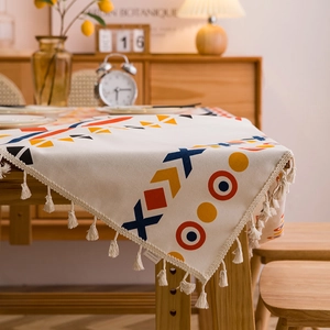 Bohemian cotton linen tablecloth with geometric patterns and beige tassels on wood table