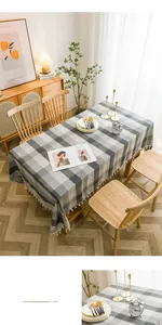 Close-up of grey plaid waterproof tablecloth featuring elegant white cotton tassels