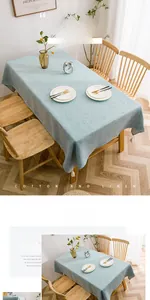 Detail of light blue cotton linen tablecloth with white tassel trim in a Nordic dining setting