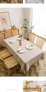 Close-up of beige linen rectangular tablecloth featuring delicate white cotton tassels
