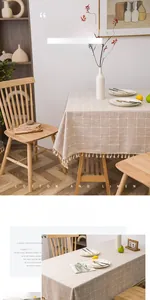 Close-up of thickened beige linen tablecloth with white grid patterns and fringe details
