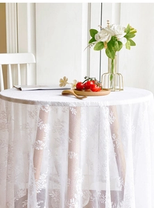 Macro shot of white hollow lace tablecloth with intricate floral embroidery patterns