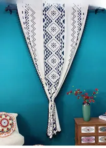 Detail of blue and white geometric print curtain with black tassels and elegant drapes