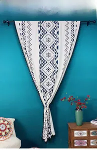 Detail of bohemian cotton linen curtain with blue floral print and black tassel fringe