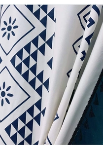 Close-up of Bohemian cotton linen curtain with navy geometric prints and black tassels
