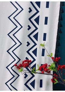 Detail of bohemian curtain with blue geometric prints and black fringe tassels