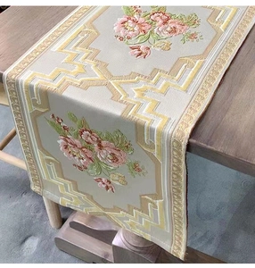 Detail of embroidered floral table runner on wooden table with elegant patterns