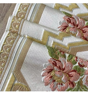 Detailed embroidery of pink peonies and golden patterns on premium white satin fabric