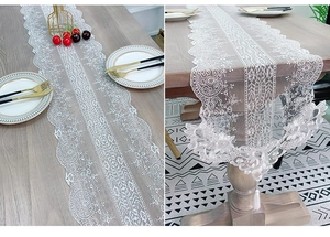 Detailed embroidery texture of white lace table runner with elegant tassels and wavy edges