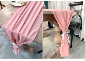 Detailed view of pink chiffon table runner with elegant white ribbon ties for wedding decor