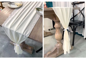 Detail of cream white chiffon table runner with decorative ribbons for wedding decor