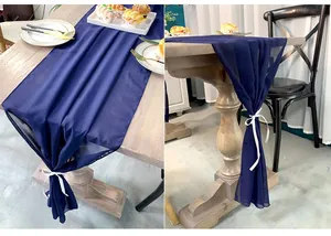 Detailed texture of dark blue chiffon table runner tied with white decorative ribbon