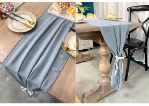 Close-up of blue chiffon table runner with draped texture and white ribbon tie detail