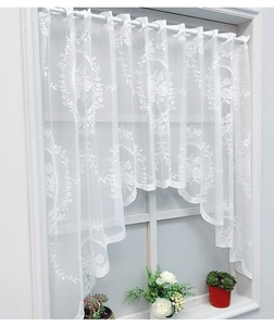 Detail of white floral lace cafe curtain with scalloped edges and rod pocket design