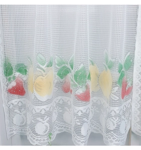 Detailed close-up of white lace kitchen curtain featuring strawberry fruit embroidery
