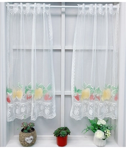 Close-up of white lace kitchen cafe curtain with colorful fruit embroidery and wavy hem