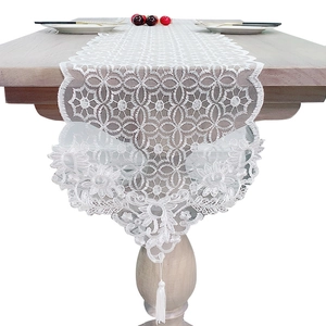 Elegant white lace table runner with geometric floral patterns and tassel decorations