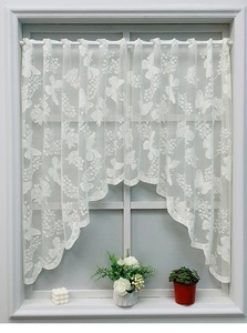 Macro detail of white lace cafe curtain featuring butterfly and rose floral embroidery