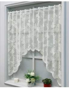 Detail of white Nordic lace cafe curtain with butterfly pattern and wavy scalloped edge