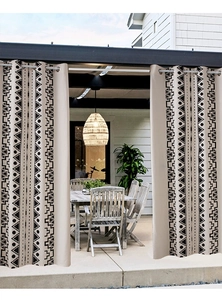 Detail of bohemian outdoor curtain with black geometric tribal print and silver metal grommets