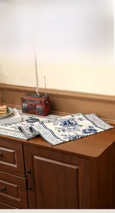 Detail of blue rose floral table runner showing woven texture on a wooden cabinet