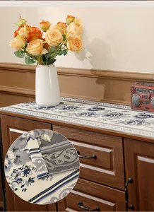 Detailed close-up of blue floral embroidery on beige jacquard table runner fabric
