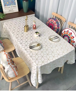 Detail showing white rectangle tablecloth with gold geometric grid patterns and luxury texture